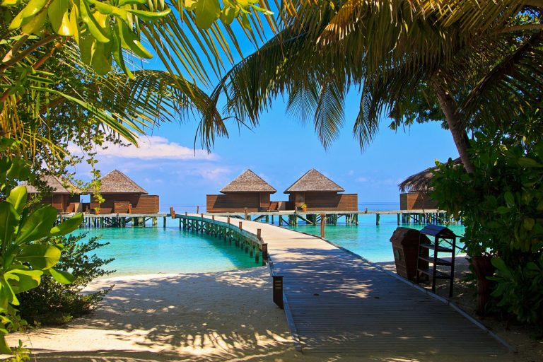 Overwater bungalows on turquoise water at a tropical all-inclusive resort
